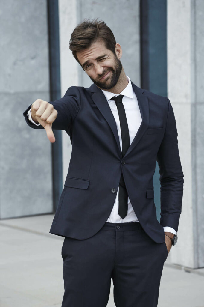 young man in suit showing thumbs down